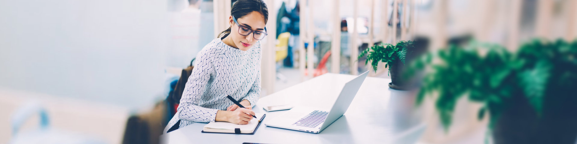 woman in eyewear working schedule writing in notebook